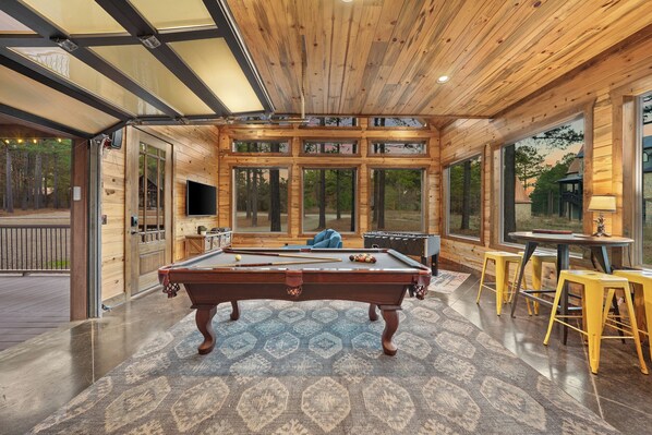 Game nights with a view—this separate game room with a garage door is all about fun, relaxation, and connection with nature.
