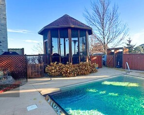 Gazebo, overlooking the sparkling pool and surrounded by lush landscaping. 