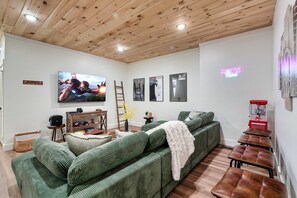 Theater room with 70 inch TV, Karaoke machine, PS4 game console with 2 remotes.