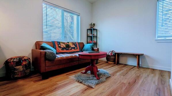 Living room seating area with smart TV. Couch folds out to a double bed. 
