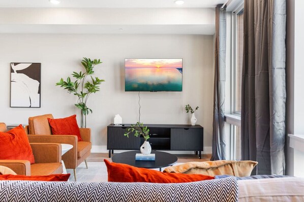 Modern living room that is beautifully bright and spacious, creating a warm and inviting atmosphere. The room is thoughtfully designed to offer both style and comfort, making it a perfect space to relax and unwind.