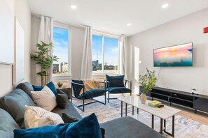 A contemporary living room with a flat-screen TV, designed for comfort and leisure activities.
