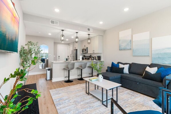 A contemporary living room with a flat-screen TV, designed for comfort and leisure activities.