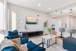 A contemporary living room with a flat-screen TV, designed for comfort and leisure activities.