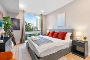Bedroom with king-sized bed, full-length mirror and a TV, perfect for lounging and enjoying your favorite entertainment.