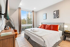 Bedroom with King-sized bed, full-length mirror and a TV, perfect for lounging and enjoying your favorite entertainment.