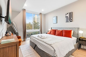 Bedroom with King-sized bed, full-length mirror and a TV, perfect for lounging and enjoying your favorite entertainment.