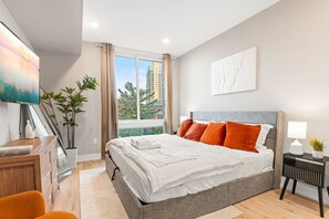 Bedroom with King-sized bed, full-length mirror and a TV, perfect for lounging and enjoying your favorite entertainment.