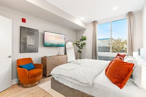 Bedroom with King-sized bed, full-length mirror and a TV, perfect for lounging and enjoying your favorite entertainment.