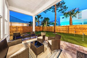Outdoor space with 5 hole putting green and plenty of seating under the covered porch
