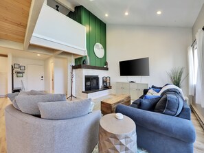 Bright and spacious living room, newly remodeled, featuring a cozy wood-burning fireplace