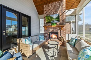 Cozy up by the fire on the peaceful screened in patio and watch TV 