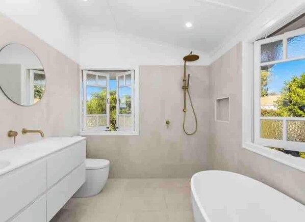 Open Rain Shower and Egg Shaped Bath along with Stone double sinks and mirrors