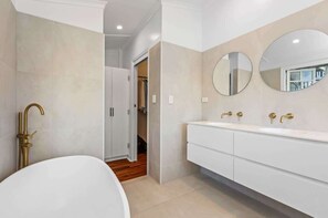 Relax in the comfortable half egg shell bath with gold fittings and hand held shower - a wonderful place to prepare for a gala, wedding or big event