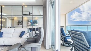 Sliding glass doors to the balcony open double wide to let in the sea breeze.