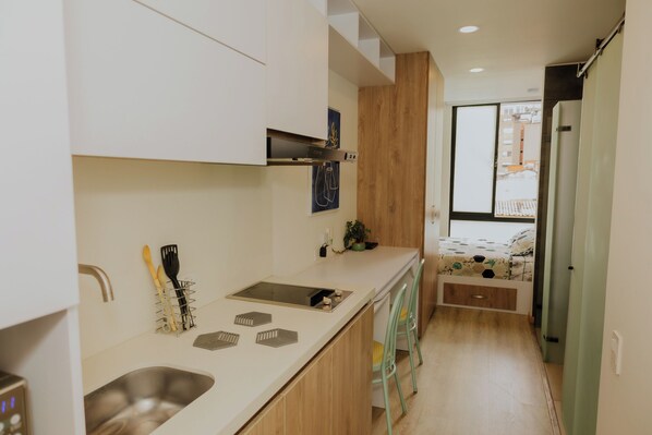 Miniapartamento moderno con cocina equipada y cama doble.