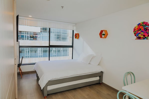 Estudio moderno en Usaquén con cama doble, escritorio y luz natural.