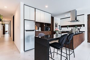 Sleek, fully equipped kitchen with a spacious island and premium appliances, ready for all your culinary creations.