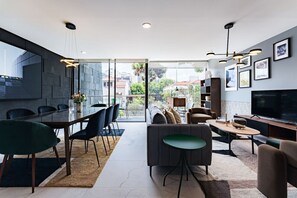 Elegant living and dining area with plush seating and a view of the lush outdoor surroundings.