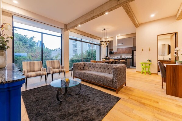Bright living space with large windows and cozy seating.