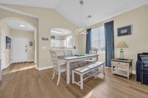 The dining area boasts a farm table that seats six, ideal for family meals.