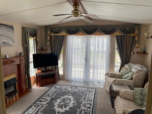 Good Size Living Room 
TV
Leather 3 Piece Suite 
French Doors Leading To Outdoor Decking 