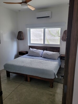 2nd bedroom with king bed, ensuite bathroom, TV, AC, fan and closet 