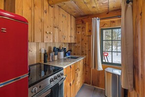 The kitchen has a full sized electric range, dishes and cookware.