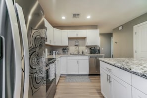 Enjoy the convenience of top-notch appliances, ample counter space, and a cozy dining area for shared culinary experiences.