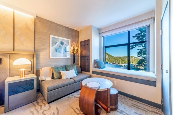 Living area has couch with queen sized sleeper sofa, coffee table, and window nook.