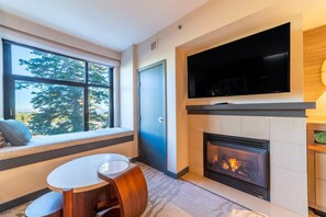 Living room has large flatscreen TV and gas burning fireplace.