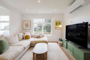 The light-filled living area offers a sofa and chaise to kick back and watch TV, while split system air conditioning ensures year-round comfort.