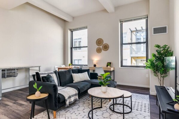 The living room’s plush seating beckons you to sink in and relax, surrounded by light and airy decor.