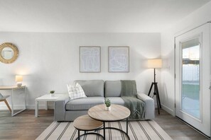 Bright and airy living room with plush seating, a large TV, and tasteful decor, creating the perfect space for relaxation and entertainment.