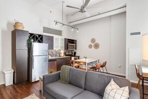 The living room’s plush seating beckons you to sink in and relax, surrounded by light and airy decor.