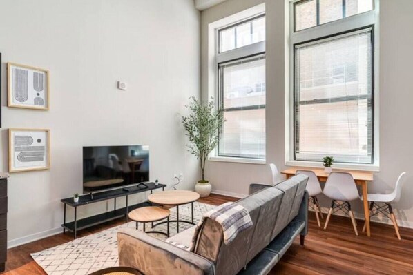 Bright and airy living room with plush seating, a large TV, and tasteful decor, creating the perfect space for relaxation and entertainment.