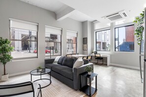 The living room’s plush seating beckons you to sink in and relax, surrounded by light and airy decor.