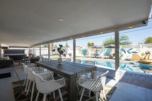 The expansive covered patio is ideal for outdoor dining under the desert sky, sharing a friendly toast in the cozy seating area, or slipping into the hot tub for ultimate relaxation.