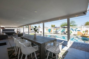 The expansive covered patio is ideal for outdoor dining under the desert sky, sharing a friendly toast in the cozy seating area, or slipping into the hot tub for ultimate relaxation.