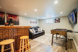 The space features a comfy couch, TV, foosball table. 