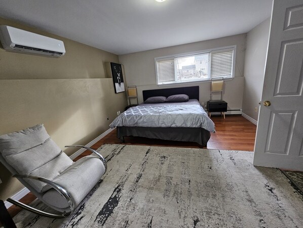 A spacious room featuring a king-sized bed and a rocking chair.