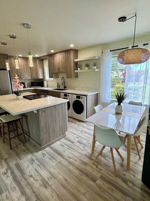 Well-stocked kitchen: dishwasher, washer/dryer and dining areas.