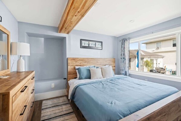 Unwind in this serene bedroom featuring a comfortable king bed, natural wood decor, and a TV for your entertainment.