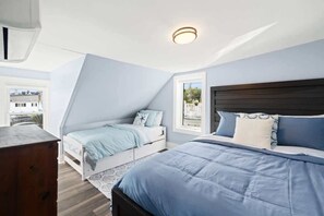 This spacious room features a queen and twin bed, along with darkening shades to ensure a restful and private stay.
