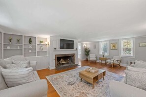 Gather with family and friends in the expansive living room, featuring a large fireplace and comfortable seating for everyone.