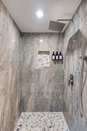 Enjoy the flexibility of a handheld shower head in this beautifully tiled walk-in shower, with complimentary shampoo, conditioner, and body wash.