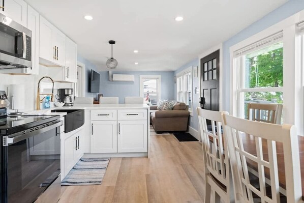 Cook and dine in style with a waterfall island and chairs in this bright, open-concept kitchen designed for entertaining.