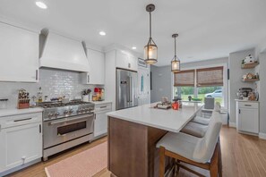 Create culinary masterpieces in our state-of-the-art chef's kitchen, featuring a 36" gas range, high-end Thor stainless steel appliances, quartz countertops, and a spacious island. Ideal for family meals or entertaining guests.