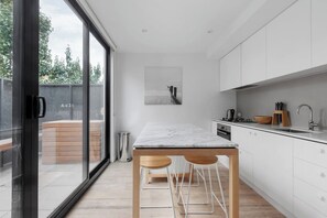 The sleek kitchen is designed around a centrepiece island bench, where you can sit down to a meal at home.
