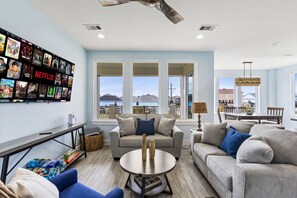 Bright living area with cozy seating, Smart TV, and large windows with views.